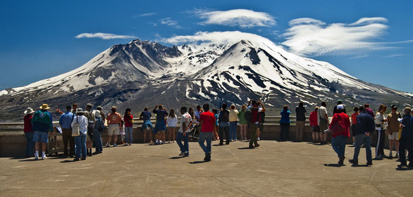 People standing against snowcapped mountains