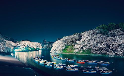 Boats moored on river against clear blue sky