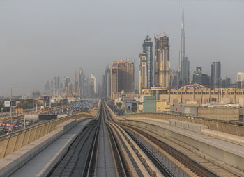 High angle view of railroad tracks by buildings against sky