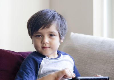 Portrait of cute boy sitting at home