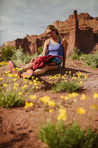 Peaceful hiker ponders life amidst yellow desert flower under red rock