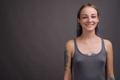 Portrait of a smiling young woman against black background