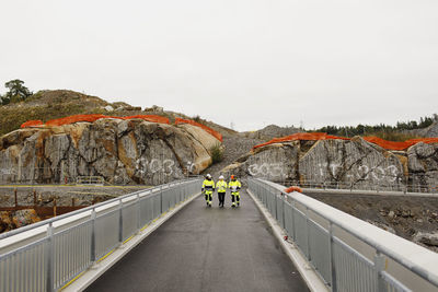 Engineers in reflective clothing walking on bridge