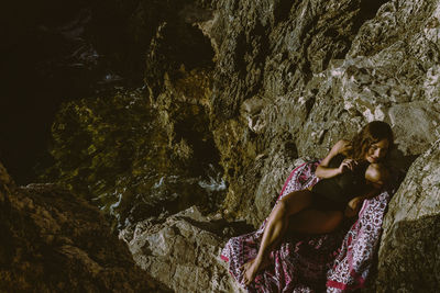 High angle view of woman lying on rock