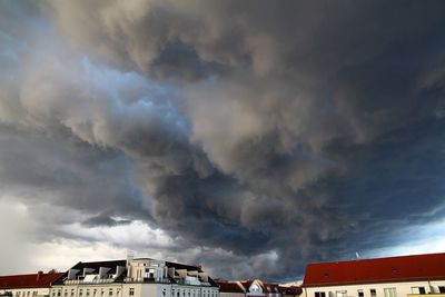 Low angle view of buildings against cloudy sky