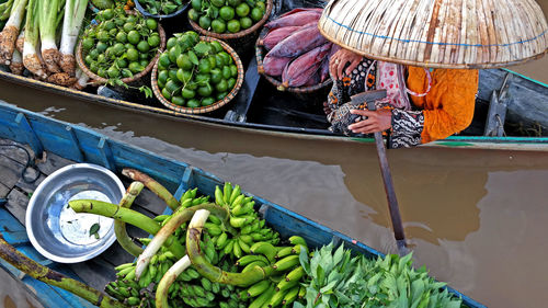 High angle view of woman selling vegetables on boat at river