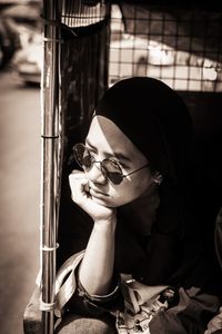 Portrait of young woman holding eyeglasses