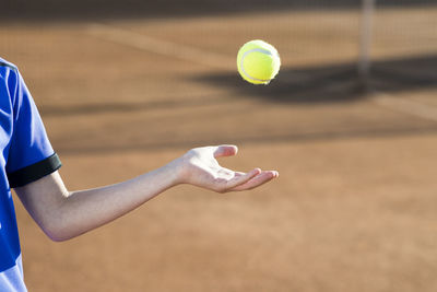 Midsection of man playing tennis