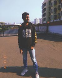 Full length portrait of young man standing in city