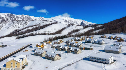 Scenic view of snowcapped mountains against blue sky