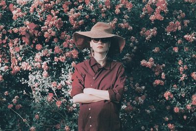 Man wearing hat standing against plants