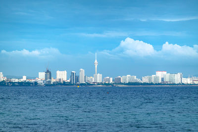 View of buildings in city against cloudy sky