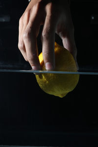 Whole yellow lemons are thrown into the aquarium and created water splashes on a black background