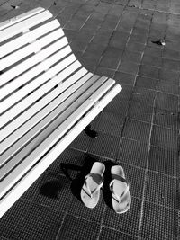 High angle view of flip-flops by bench