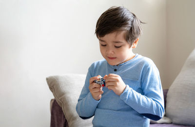 Boy sitting on sofa at home