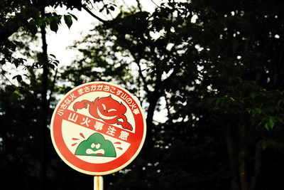 Low angle view of road sign against trees
