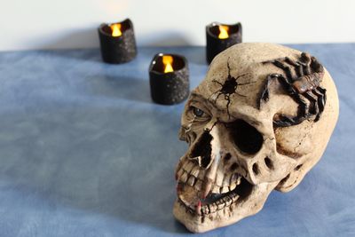 Close-up of human skull and fire on table
