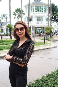 Portrait of woman wearing sunglasses while standing in city