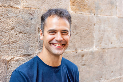 Portrait of smiling man standing against wall