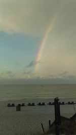 Scenic view of rainbow over sea against sky