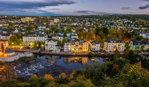 Scenic view of river by city against sky