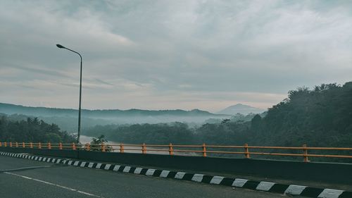 Road by mountains against sky