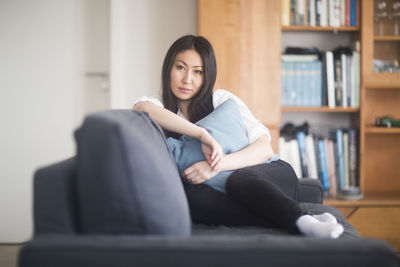 Young woman at home in a living room lying on a couch