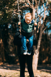 Portrait of little adorable boy swinging