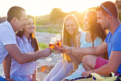 Group of people drinking wine during sunset