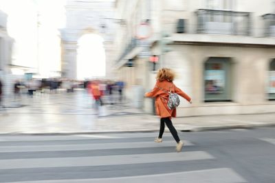 Full length rear view of man walking on road