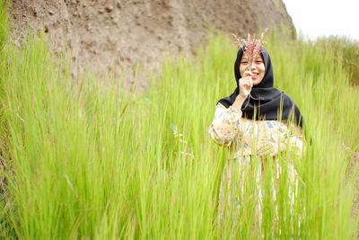Smiling young woman standing on field