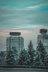 Buildings in city against cloudy sky