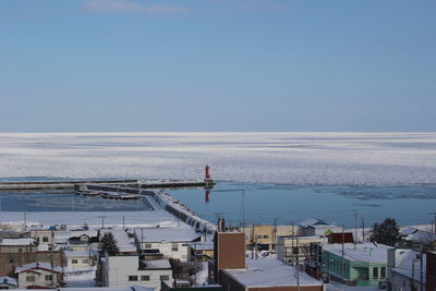 Buildings by sea against sky