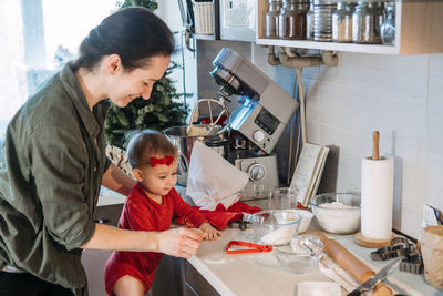 Cozy christmas at home. family preparation holiday dessert. mother and baby toddler daughter play