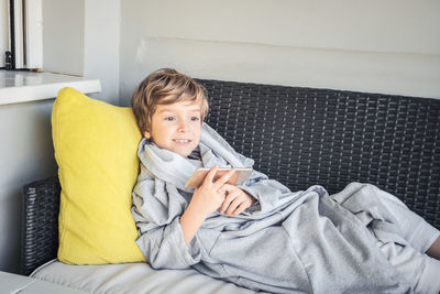 Portrait of cute boy relaxing on bed at home