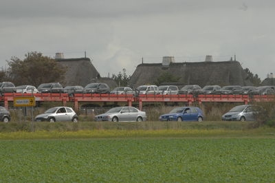 Cars on field against sky