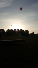 Silhouette of hot air balloons against sky during sunset