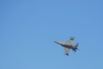 Low angle view of airplane against clear blue sky