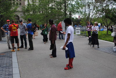 People standing on road with trees