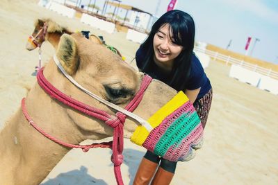 Woman with camel on sand