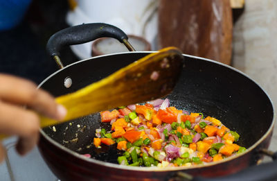 Midsection of person preparing food in container