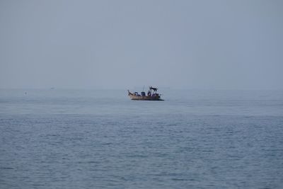 Boat sailing in sea against clear sky