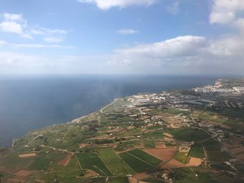 Aerial view of sea and land against sky