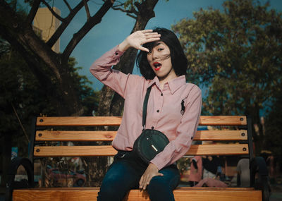 Full length of young man sitting on bench