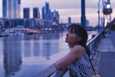 Side view of young woman looking away in city