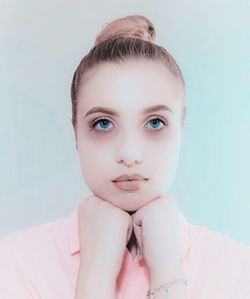 Portrait of woman with hands on chin against wall