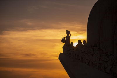 Low angle view of silhouette man standing against sky during sunset