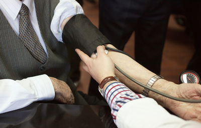 Cropped image of doctor examining patient in hospital