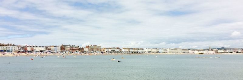 Distant view of weymouth beach against sky