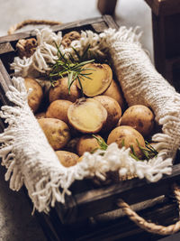 Baby potato in wooden brown box with napkin and rosemary